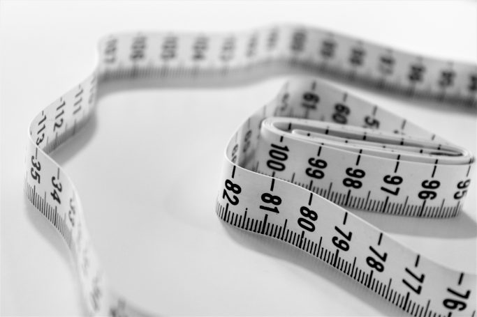 A white measuring tape against a white background, with the numbers in black.
